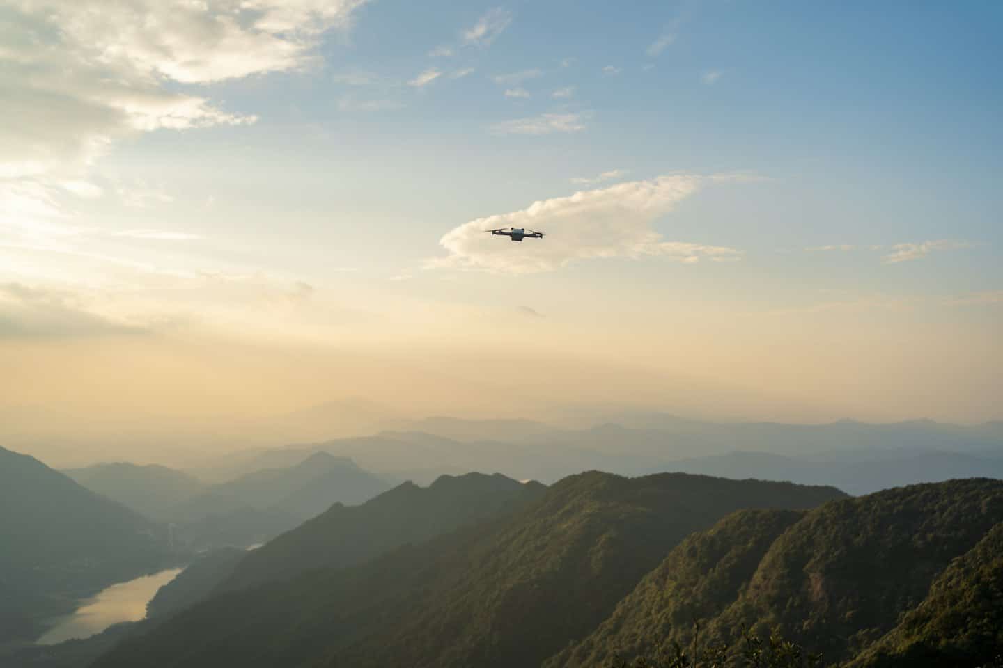 Dron leci wysoko nad górami i krętą rzeką.